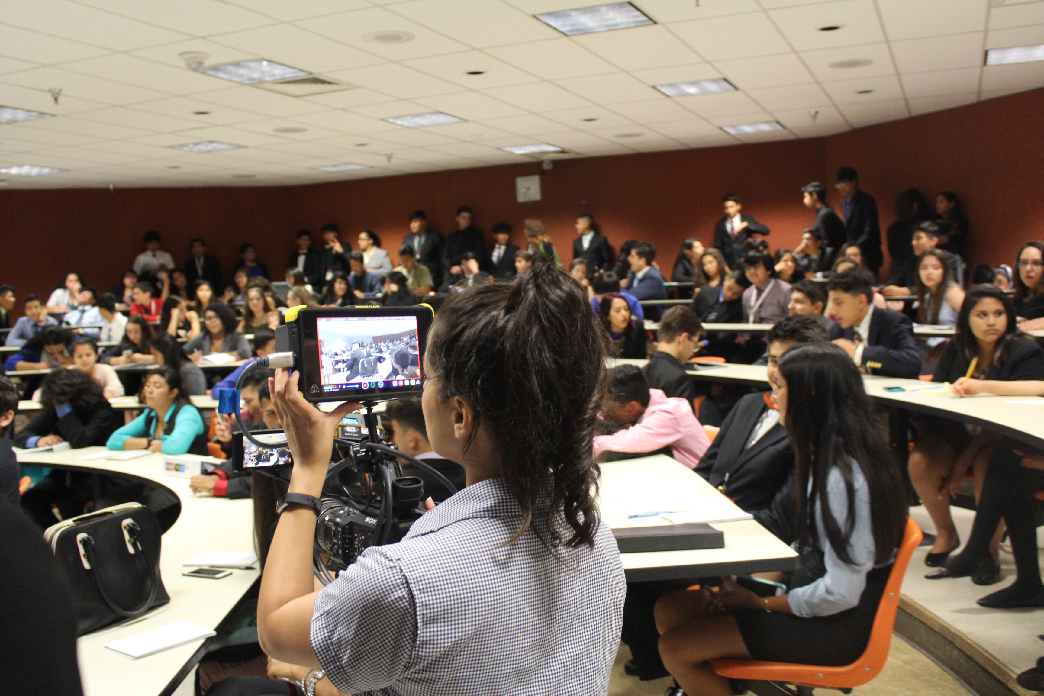 A member of the DishLATINO crew films students at the 2016 Texas Ambassador Great Debate
